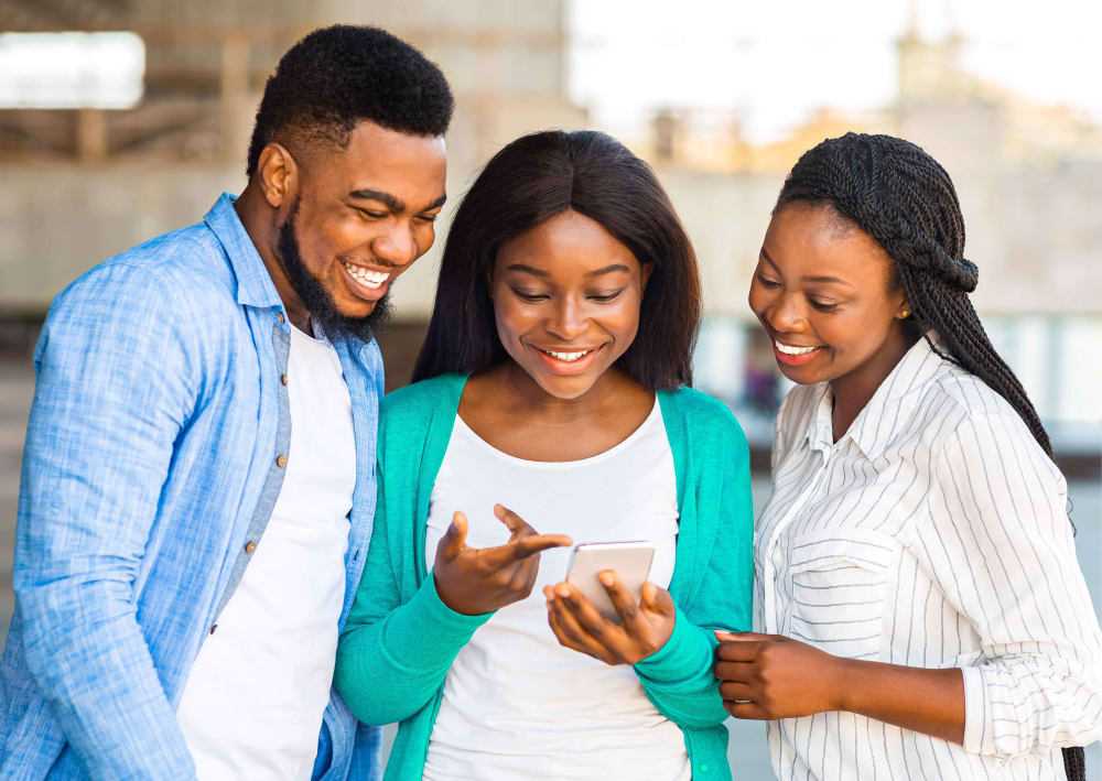 two ladies and a guy looking at a phone with XENO app